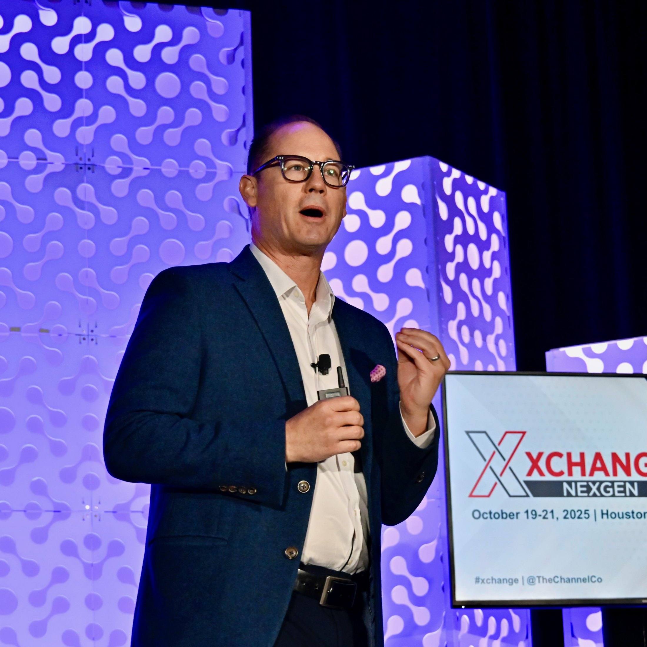 Travis Woods delivering a keynote on stage at XChange NexGen in Houston, October 2025