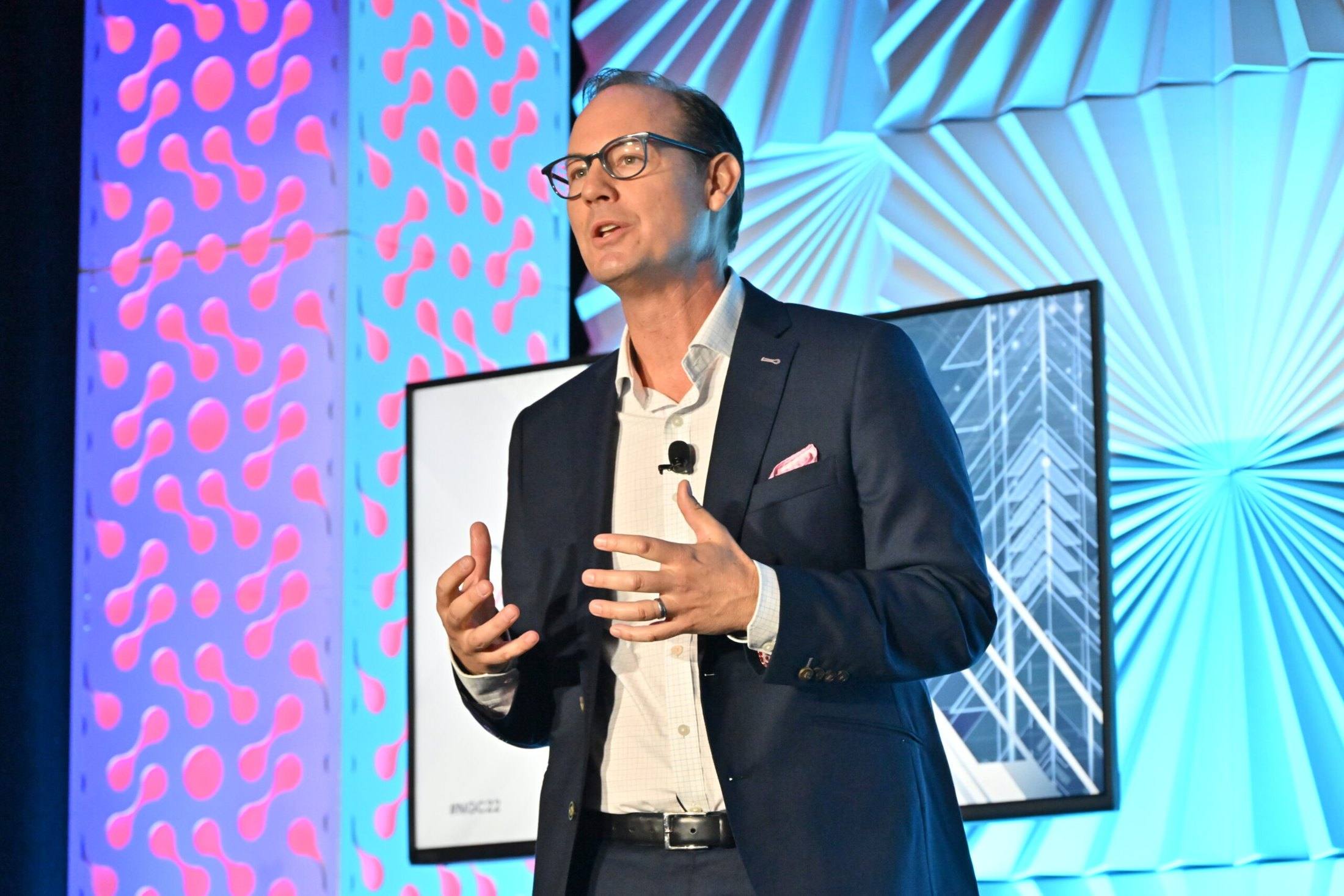 Travis Woods presenting to an audience on the XChange stage